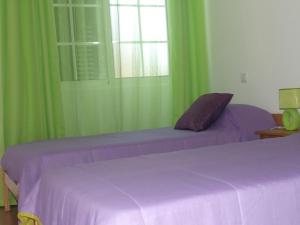 a bedroom with two beds and green curtains at Maison de l' Épicier in Funchal