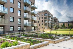 een appartementencomplex met een tuin ervoor bij Citystay - Mill Park Apartments in Cambridge