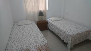 two beds sitting next to each other in a room at Apartment La Huerta de Beniajan 50 por ciento dcto directo in Murcia