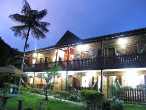 a house at night with a palm tree in front at Country Inn, Suites & Condo in São Pedro da Serra