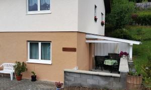 a house with a patio with a table and chairs at FeWo mit Terrasse - Apartment with terrace in Rockeskyll