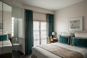 Habitación de hotel con cama grande y ventana en Hôtel de la Place du Louvre - Esprit de France en París