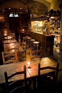 un ristorante con tavoli e sedie in legno e un bar di La Taverna del Metallo Rooms a La Spezia