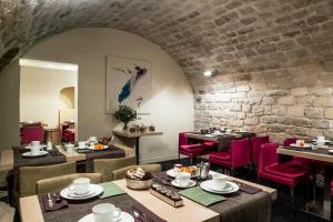 a restaurant with tables and chairs and a brick wall at H&ocirc;tel de la Place du Louvre - Esprit de France in Paris
