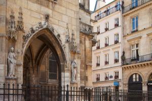 un bâtiment avec une arche devant un bâtiment dans l'établissement Hôtel de la Place du Louvre - Esprit de France, à Paris