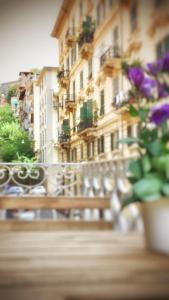 a bench with flowers in front of a building at La Taverna del Metallo Rooms in La Spezia