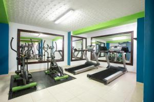 a gym with several tread machines and mirrors at Decameron Las Heliconias - All Inclusive in Quimbaya