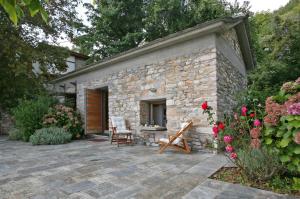 ヴィジツァにあるPelion Belvedere - The Modern Cottageの石造りの建物で、パティオ(テーブル、椅子付)
