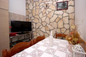 a dining room with a table and a stone wall at Apartment Vesna in Premantura