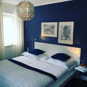 a blue bedroom with a large bed with blue walls at Hotel am Goetheberg in Obernhof