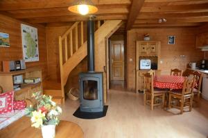uma sala de estar com um fogão a lenha numa cabina em chalet des planchettes em Marigny