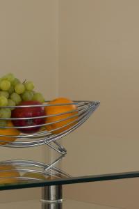 a bowl of fruit on top of a glass table at Citystay - Dove House in Cambridge