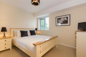 a bedroom with a bed and a flat screen tv at Citystay - Dove House in Cambridge