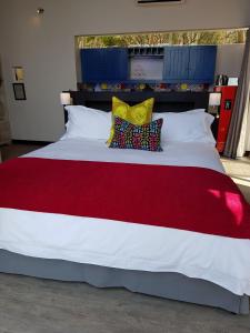 a large red and white bed with two pillows on it at Bluemere Living in White River