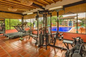 un gimnasio con equipo cardiovascular y una piscina en Decameron Panaca - All Inclusive en Quimbaya