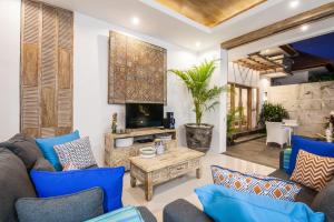 Elle comprend un salon doté d'un mobilier bleu et d'une cheminée. dans l'établissement Ambermoon Villas, à Seminyak