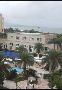 un gran edificio con piscina y palmeras en Il Campanario Villaggio room, en Florianópolis