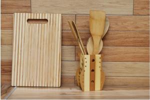 a wooden cutting board with wooden utensils in a holder at Apartment on Pichugina in Karagandy