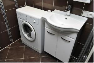 a bathroom with a washing machine and a sink at Apartment on Pichugina in Karagandy