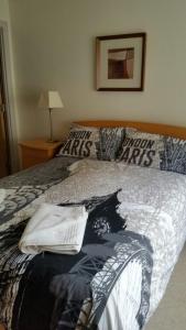 a bedroom with a bed with a black and white blanket at Harbour View Apartment Kinsale in Kinsale