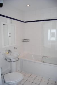a white bathroom with a toilet and a sink at Harbour View Apartment Kinsale in Kinsale