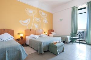 a hotel room with two beds and a balcony at Grand Hotel Mediterraneo in Santa Cesarea Terme