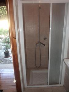 um chuveiro numa casa de banho com uma porta de vidro em Oleander Stone House em Lemona