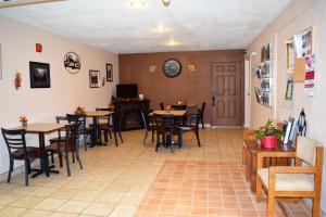 een eetkamer met tafels en stoelen en een klok aan de muur bij Country Inn Libby in Libby