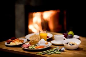 a table with plates of food and a glass of orange juice at Lannalodge in Vintrosa