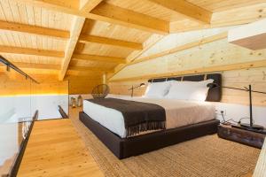 a bedroom with a large bed in a wooden ceiling at Quintãs Farm Houses in Arouca