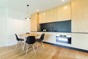 a kitchen with a table and chairs in a room at Quintãs Farm Houses in Arouca
