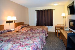 een hotelkamer met twee bedden en een flatscreen-tv bij Country Inn Libby in Libby +41 foto's