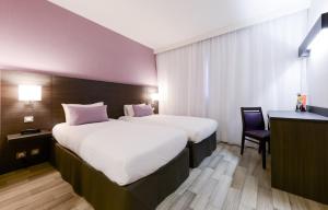 a hotel room with two beds and a desk at Hotel Eurocentre 3* Toulouse Nord in Castelnau-dʼEstrétefonds