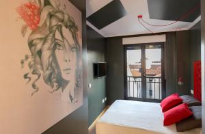 a bedroom with a painting of a woman on the wall at San Justo Plaza in Salamanca