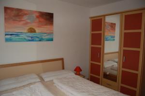 a bedroom with a bed and a cabinet at Zum Sonnenuntergang in Zingst