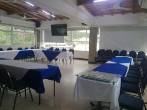 a conference room with tables and chairs and a flat screen tv at Hotel Rodadero Real in Santa Marta +86 photos