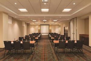una sala de conferencias con mesas y sillas. en Hyatt Place San Jose Pinares, en San José