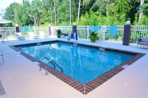 a swimming pool with a tile floor and a white fence at Best Western Plus Ruston Hotel in Ruston