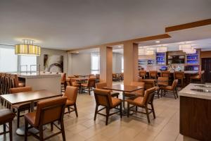 a restaurant with tables and chairs and a bar at Hyatt House Dallas Uptown in Dallas