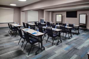 a conference room with tables and chairs and a screen at Hyatt House Dallas Uptown in Dallas