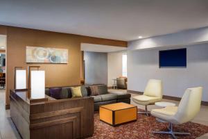 a living room with a couch and two chairs at Hyatt House Dallas Uptown in Dallas