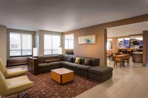 a living room with a couch and a table and chairs at Hyatt House Dallas Uptown in Dallas