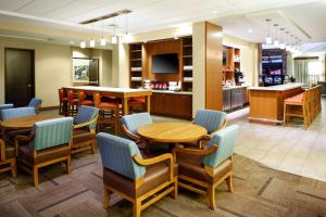 a restaurant with tables and chairs and a kitchen at Hyatt Place Columbia/Downtown/The Vista in Columbia