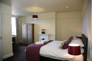 um quarto com uma cama grande e uma lareira em Gillygate Guest House em York