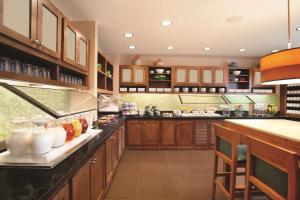 a large kitchen with wooden cabinets and a counter at Hyatt Place Denver Tech Center in Centennial