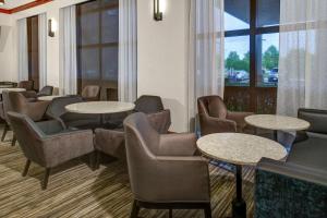 a waiting room with tables and chairs and a window at Hyatt Place Memphis Primacy Parkway in Memphis