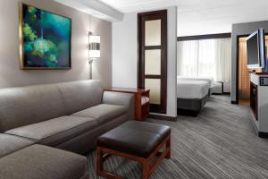 a hotel room with a couch and a bed at Hyatt Place Memphis Primacy Parkway in Memphis
