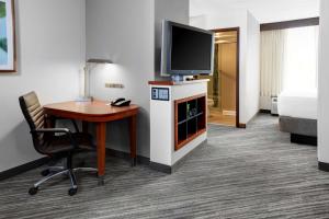 a hotel room with a desk and a tv and a bed at Hyatt Place Memphis Primacy Parkway in Memphis +29 photos