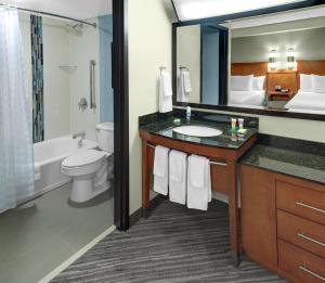 a bathroom with a sink and a toilet and a mirror at Hyatt Place Memphis Primacy Parkway in Memphis