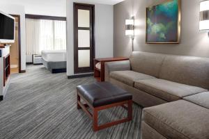 a hotel room with a couch and a bed at Hyatt Place Memphis Primacy Parkway in Memphis